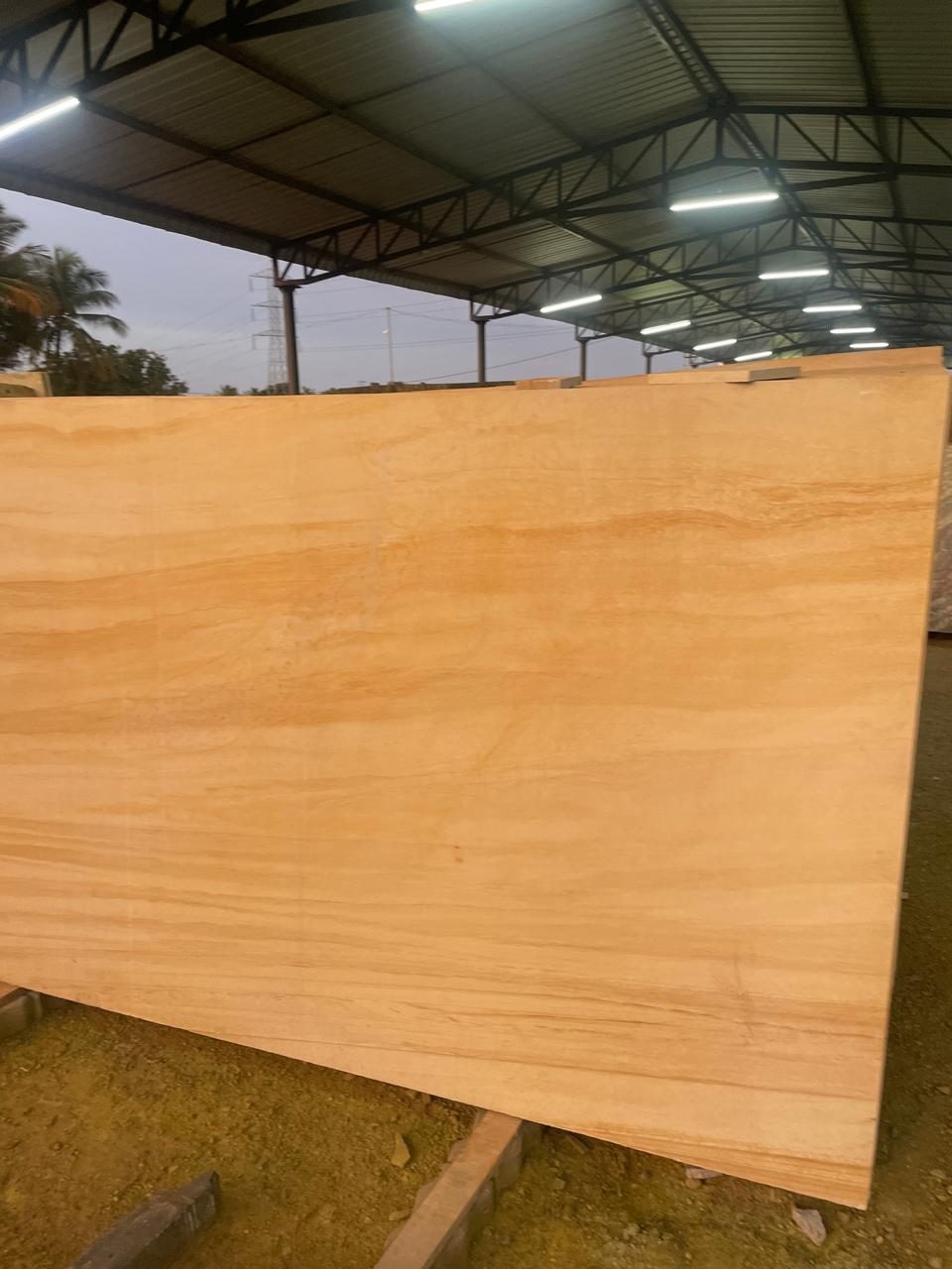 Light golden sandstone granite slab with soft horizontal banding under a shed