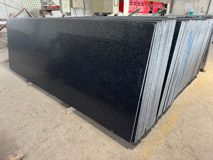 Stack of black granite slabs with a textured lappato finish in our yard