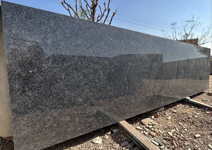 Polished grey speckled granite slab outdoors