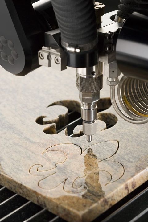 CNC machine cutting a motif into a stone slab