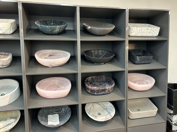 Patterned and marble-look vessel basins on grey shelving