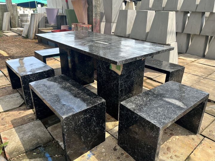 Black granite outdoor table with four stone stools